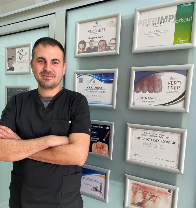 Dr Nikola Mirčić ispred zida sa sertifikatima sa kurseva