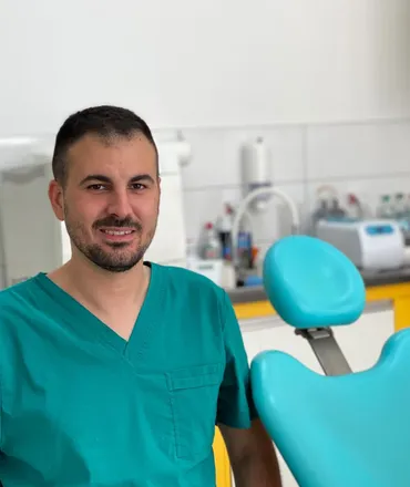 Dr Nikola Mirčić u zelenoj uniformi pored stomatološke stolice